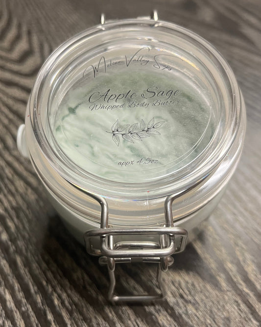Jar of green whipped body butter with a clear label. 