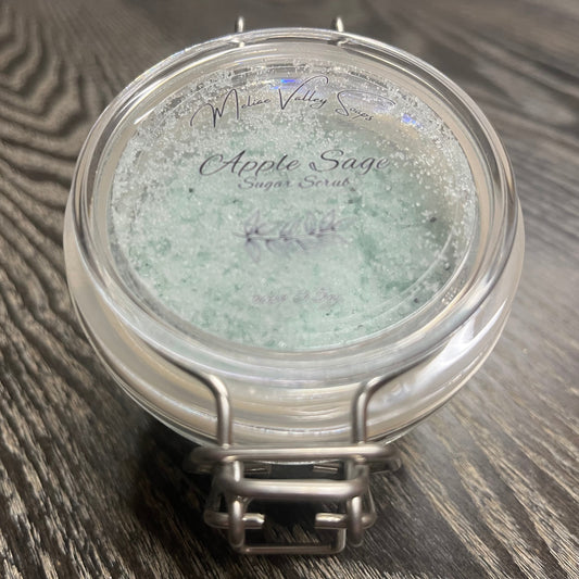 Jar of green body scrub with a clear label. 