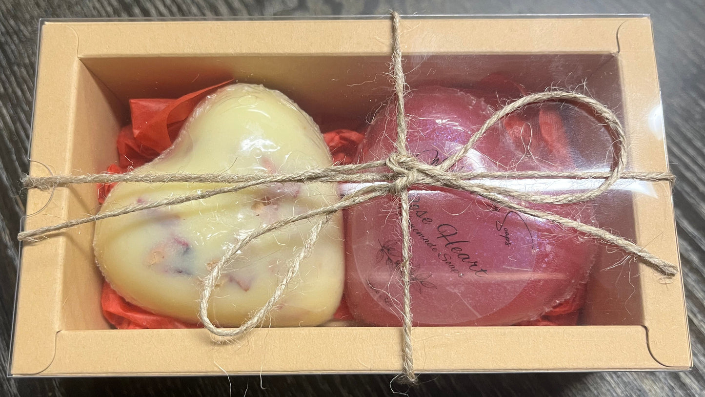 A soap and a lotion bar in a decorative box with twine on a wooden surface. 