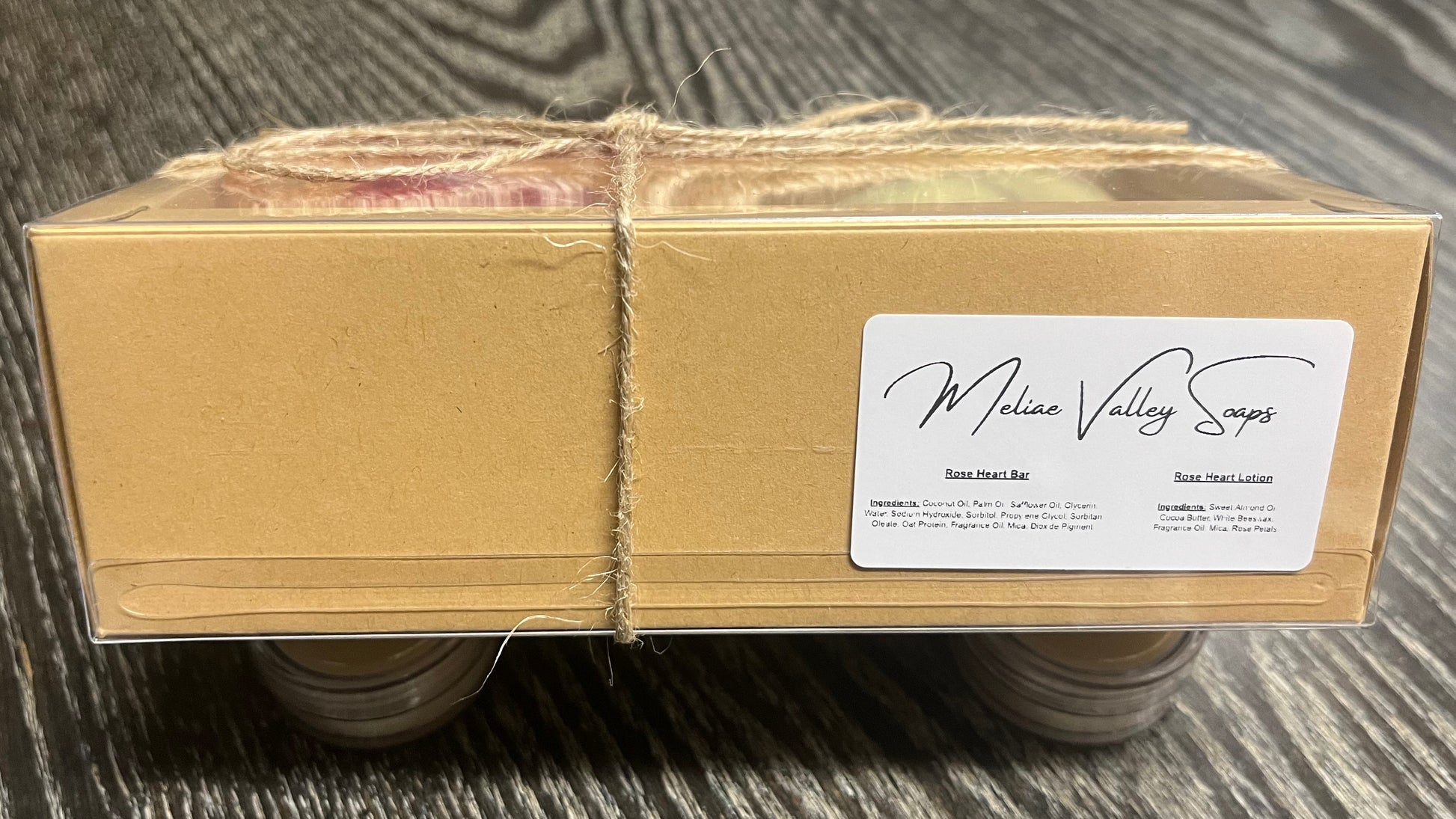A soap and a lotion bar in a decorative box with a white ingredients sticker and twine.