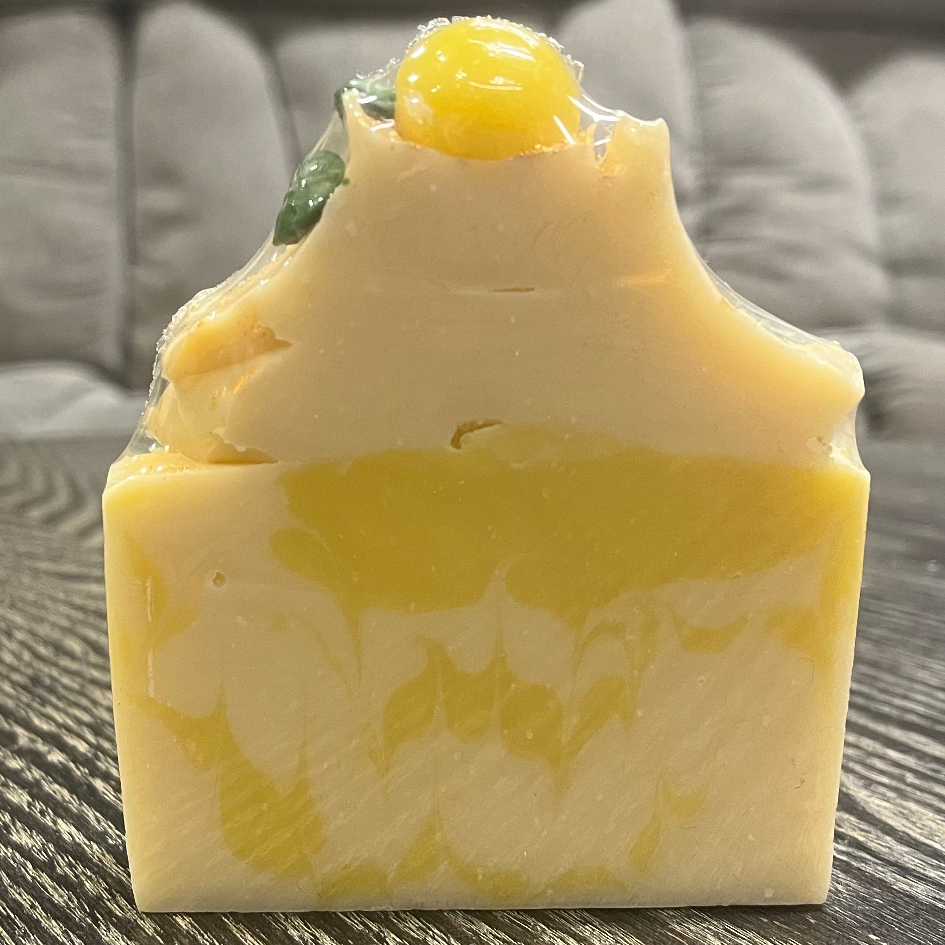 Bar of soap with a yellow and white marbled pattern on a textured surface. 