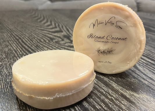 Two round soaps on a textured surface with a blurred background. 