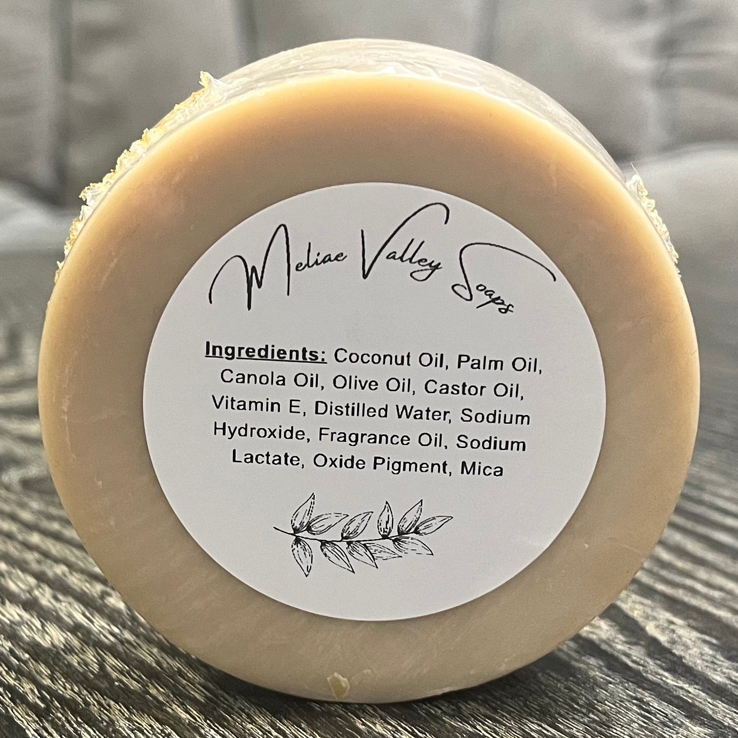 Bar of soap with an ingredients label on a textured surface. 