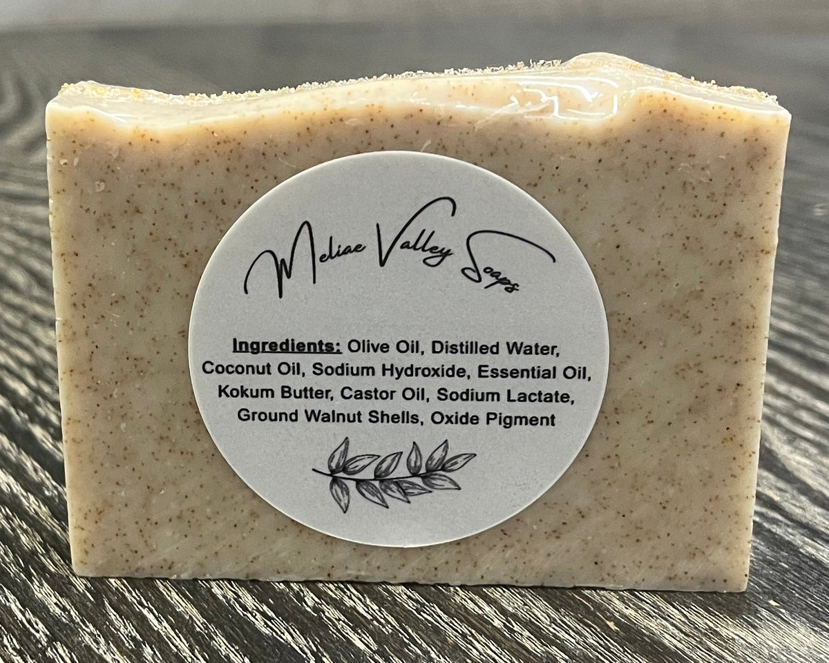 Bar of soap with a label on a wooden surface.