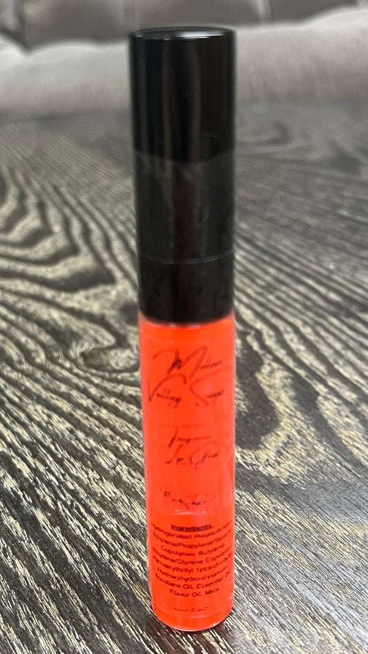 A bright orange tube of lip gloss. 