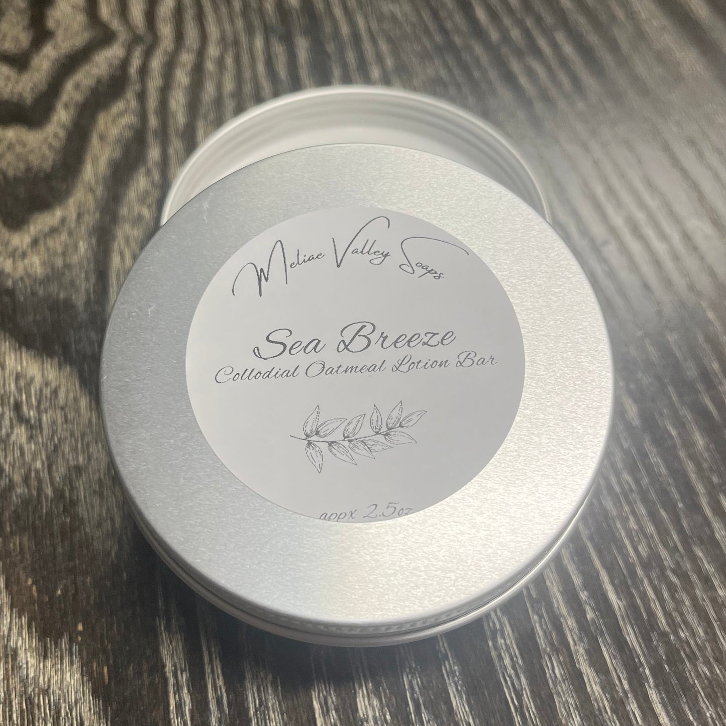 Colloidal Oatmeal lotion bar tin with label on a textured surface