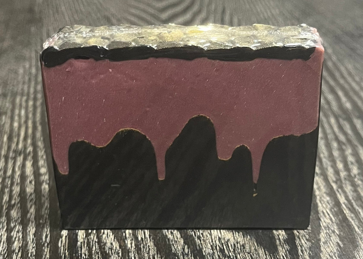 A bar of soap with a black bottom layer and a red layer made to look like blood. A thin black top layer is textured to look like gold dragon scales.