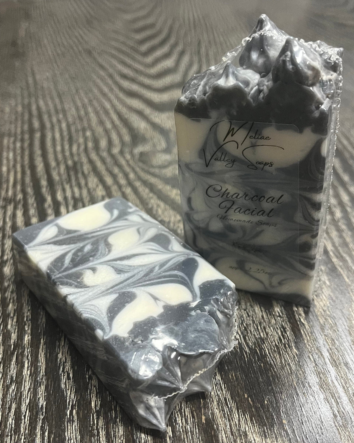 Two handmade soap bars with black and white marbled swirls. 