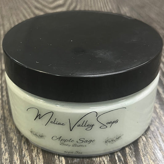 Jar of green whipped body butter with a black lid and a clear label on the front. 