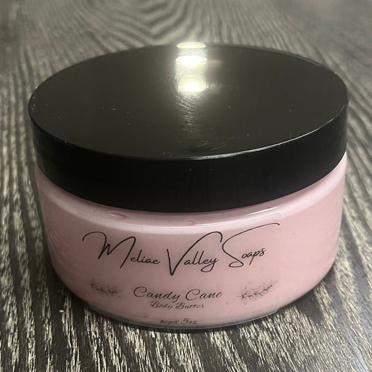Jar of pink whipped body butter with a black lid and a clear label on the front. 