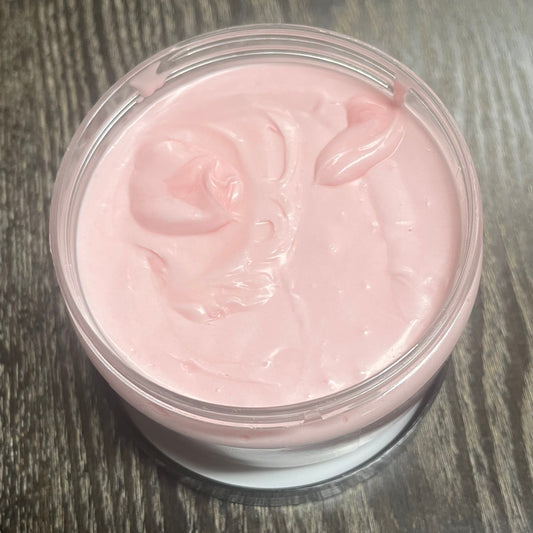 Jar of pink whipped body butter. You can slightly see a clear label on the front from this angle. 