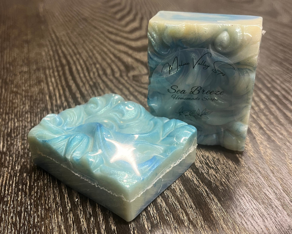 Two bars of soap. They have a wave texture and are swirled with different shades of blue and white. 