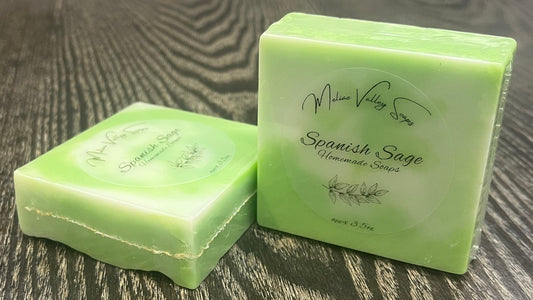 Two green and white bars of soap. They have clear labels on the front. 
