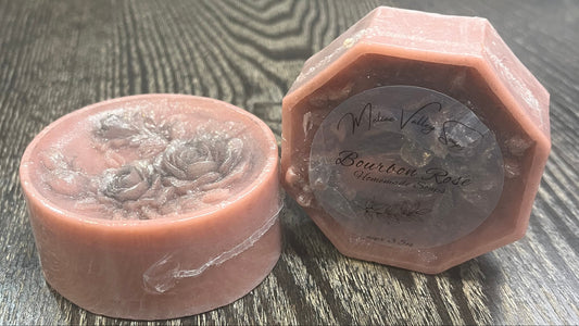 Two dusty rose bars of soap. They have clear labels on the front. 